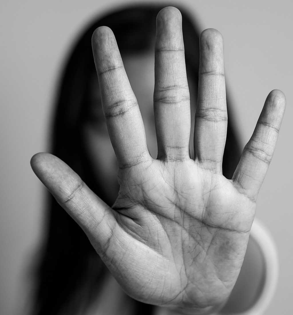 Girl holding hand up palm facing forward